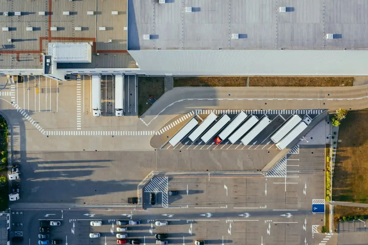 Logistikhalle mit Lkw-Andockstellen und Stellplätzen aus der Vogelperspektive, Symbolbild
