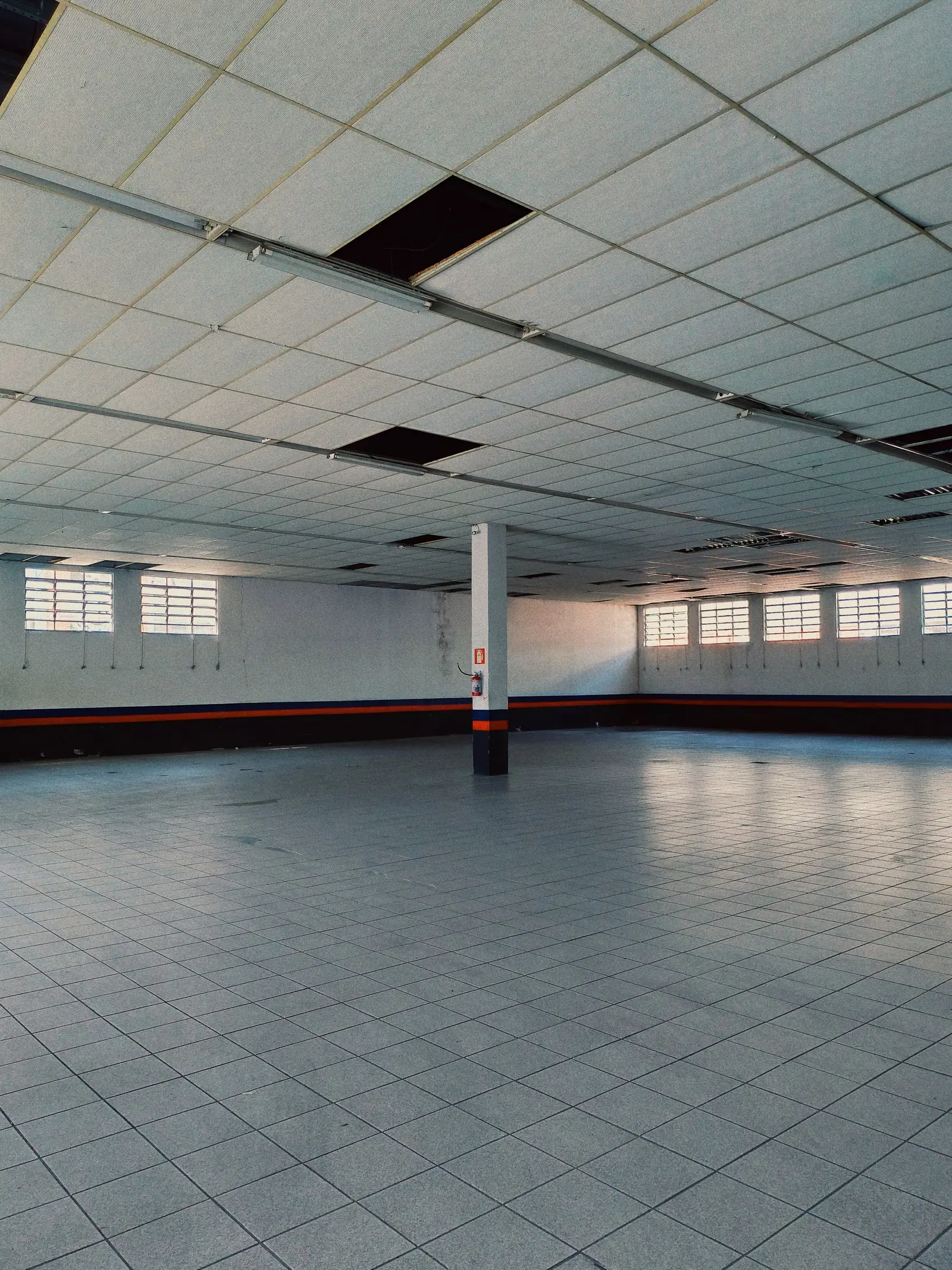 Leere helle Gewerbehalle mit Stützen und Fensterband, Symbolbild